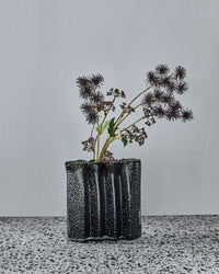 House Doctor Zuri vase in Deep Forest styled with dried seed head stems, showing its four-section design in use