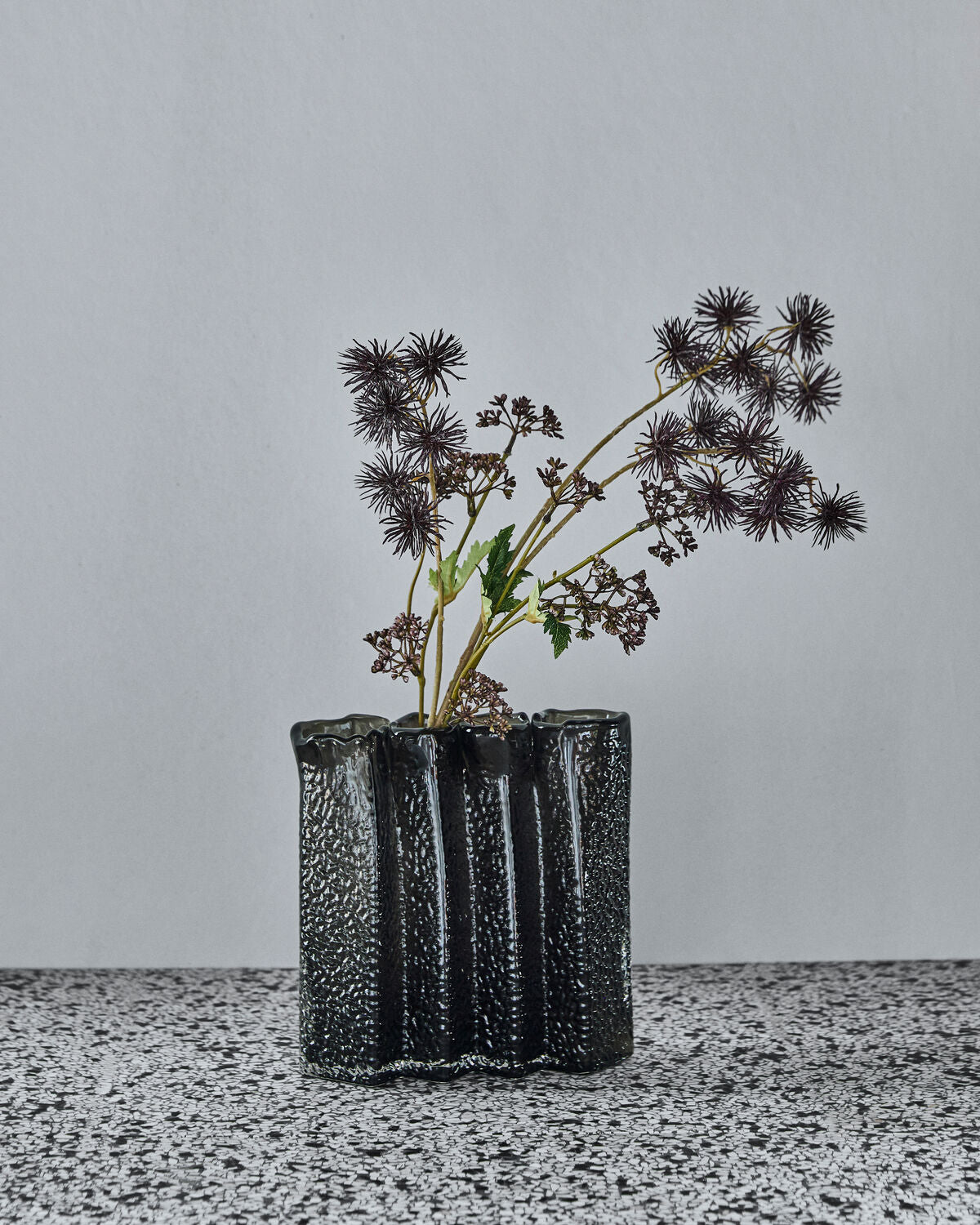 House Doctor Zuri vase in Deep Forest styled with dried seed head stems, showing its four-section design in use