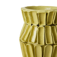 Large yellow Sculptural Vase on the floor beside a sofa