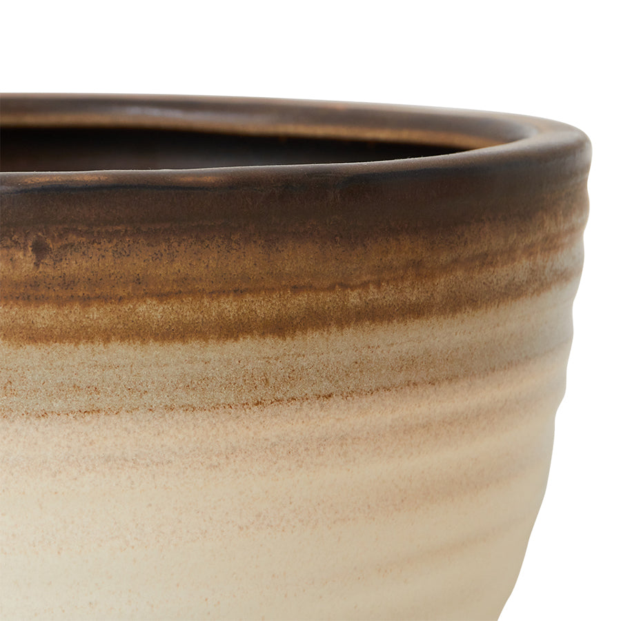 Close-up of the ribbed vanilla stoneware and caramel and brown banded rim