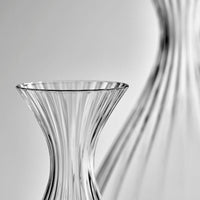 top rim of a glass caraf jug with another larger caraf in the background
