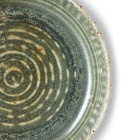Close-up of the mossy green reactive glaze and speckled rim