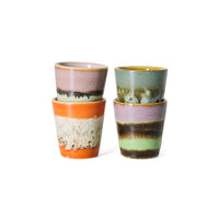 Set of four 70s ceramics ristretto mugs in Nostalgia by HKLIVING, stacked in pairs showing orange-and-cream, lilac-green-brown, pink-mint-black and sage-gold glazes
