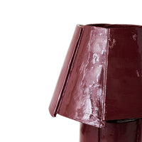 Burgundy cotton maché table lamp styled on a bedside table