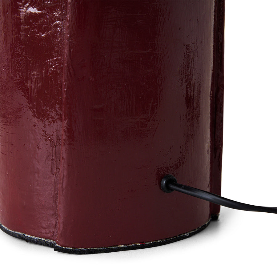 Burgundy cotton maché table lamp in a styled interior