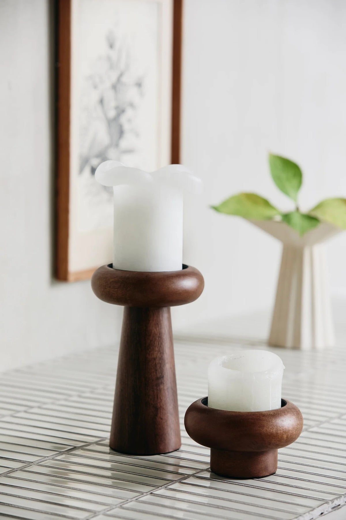 BAWE candle holder in mango wood by Nordal displayed alongside a smaller holder on a tiled table