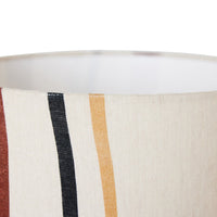close up of the top of the lamp shade showing the slightly yellow, off white of the overall colour and the top of the curving stripes with red, black, and yellow