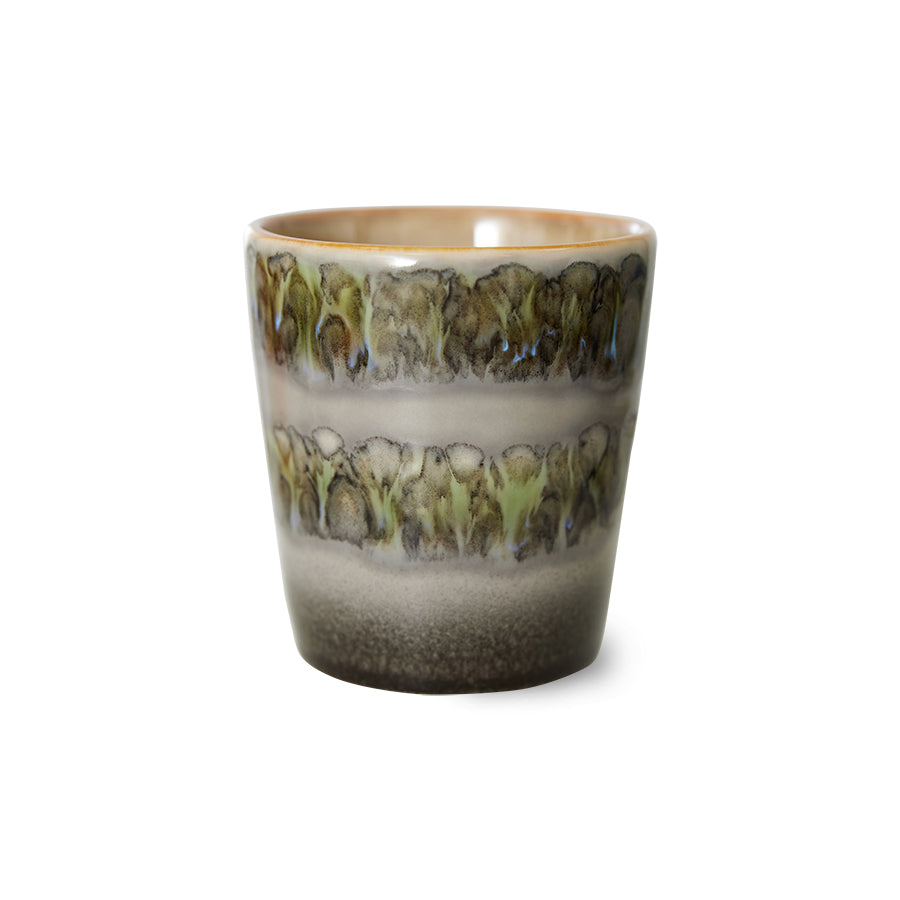 a single coffee cup with swirls of colour on the outside that looks almost like trees or thistles in greens and browns with colourful 70s joy
