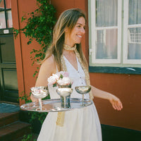 person carrying stainless steel ice cups by aida on a tray for stylish summer entertaining
