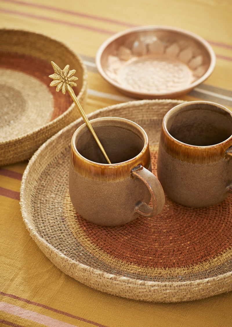 brown stoneware mugs on a woven tray for a warm, Nordic-inspired coffee moment
