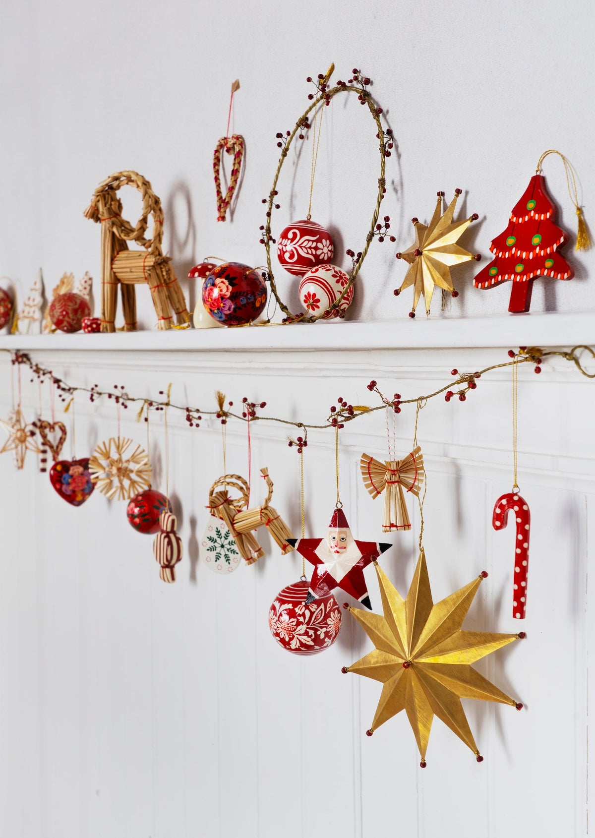 festive mantle decorated with hand painted wooden ornaments including winter mitten
