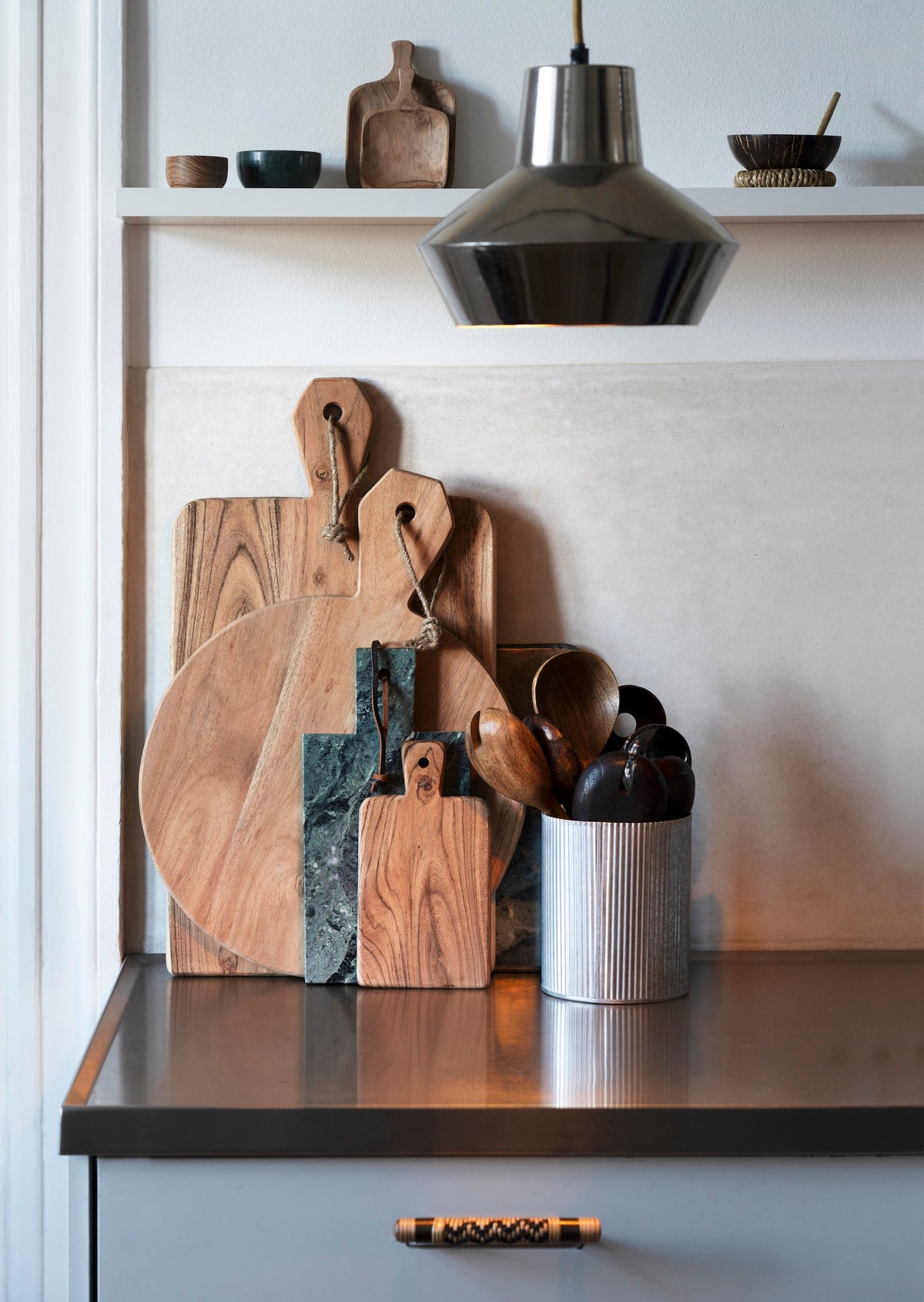 dark green marble pinch pot styled on kitchen shelf with wooden accessories
