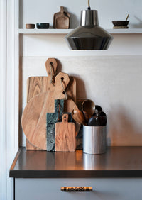dark green marble pinch pot styled on kitchen shelf with wooden accessories
