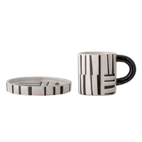 Black handle coffee cup with matching patterned saucer