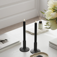 Black LED dinner candles styled on a bright spring table with warm flickering flame