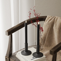 Black LED dinner candles glowing softly in a cosy winter interior