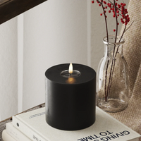 chunky black LED candle with flickering warm flame in winter-inspired home décor scene