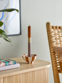 multicolour dip dye taper candle in ceramic candle holder styled on wooden cabinet