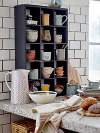 ustic kitchen shelf with assorted ceramics and green bloomingville pixie lemon juicer