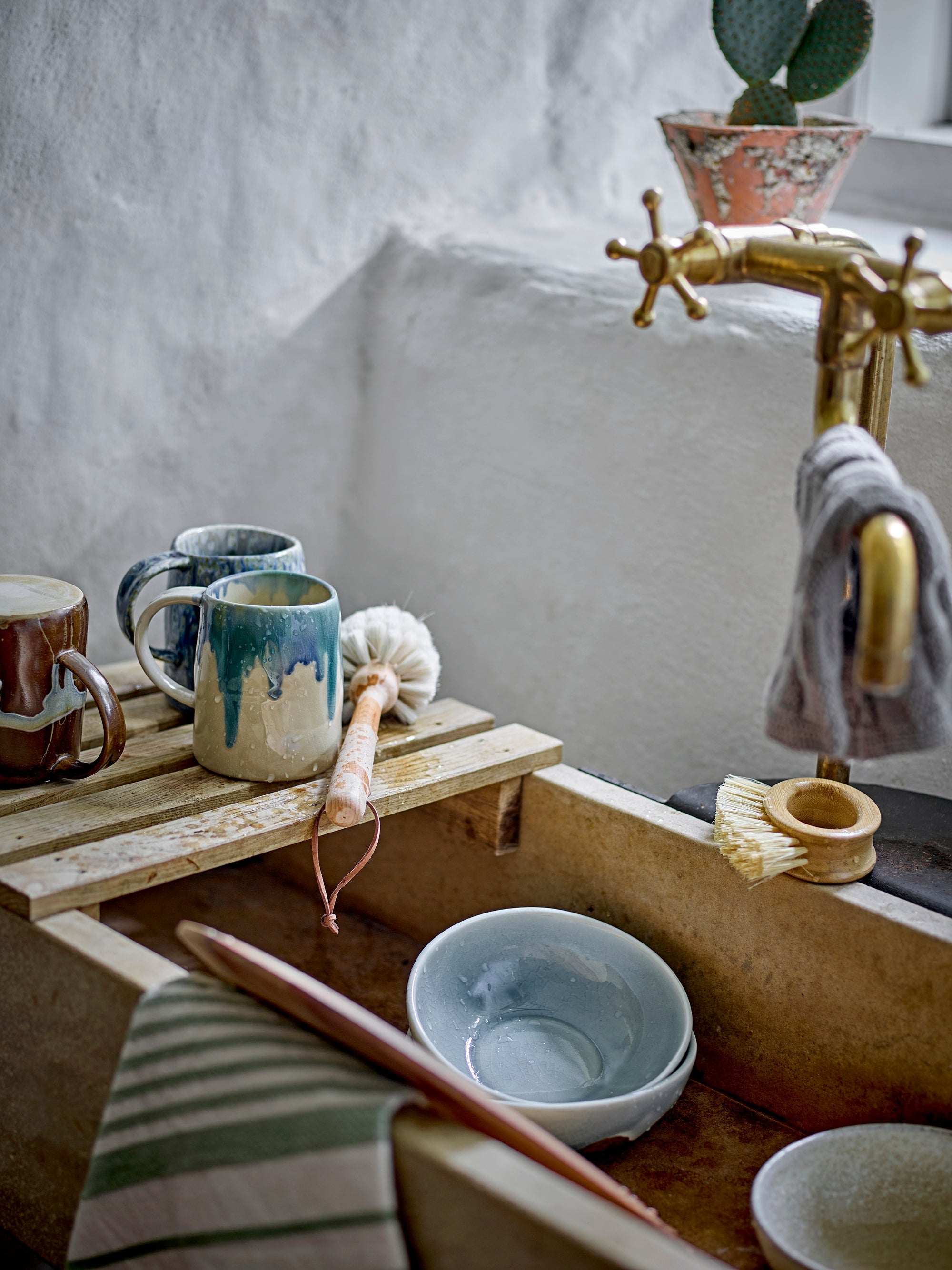 rustic stoneware mugs including the brown bloomingville yori mug styled by an old sink
