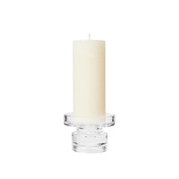 Petra clear glass candle holder with a tall cream pillar candle on top