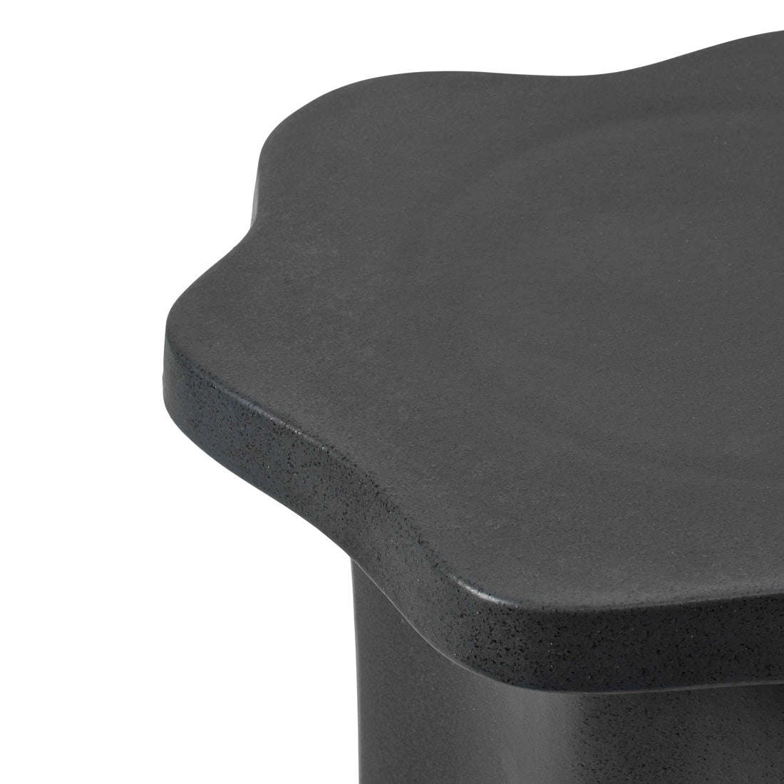 Close-up of the Sonja Pedestal Low showing its matt black glaze and curved outline