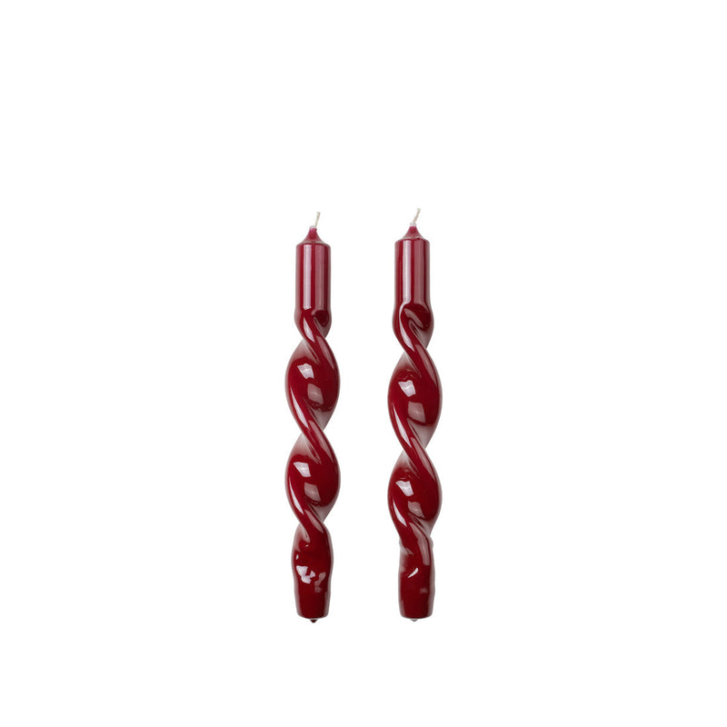 Two Broste Copenhagen glossy Twist Taper Candles in burgundy on a white background