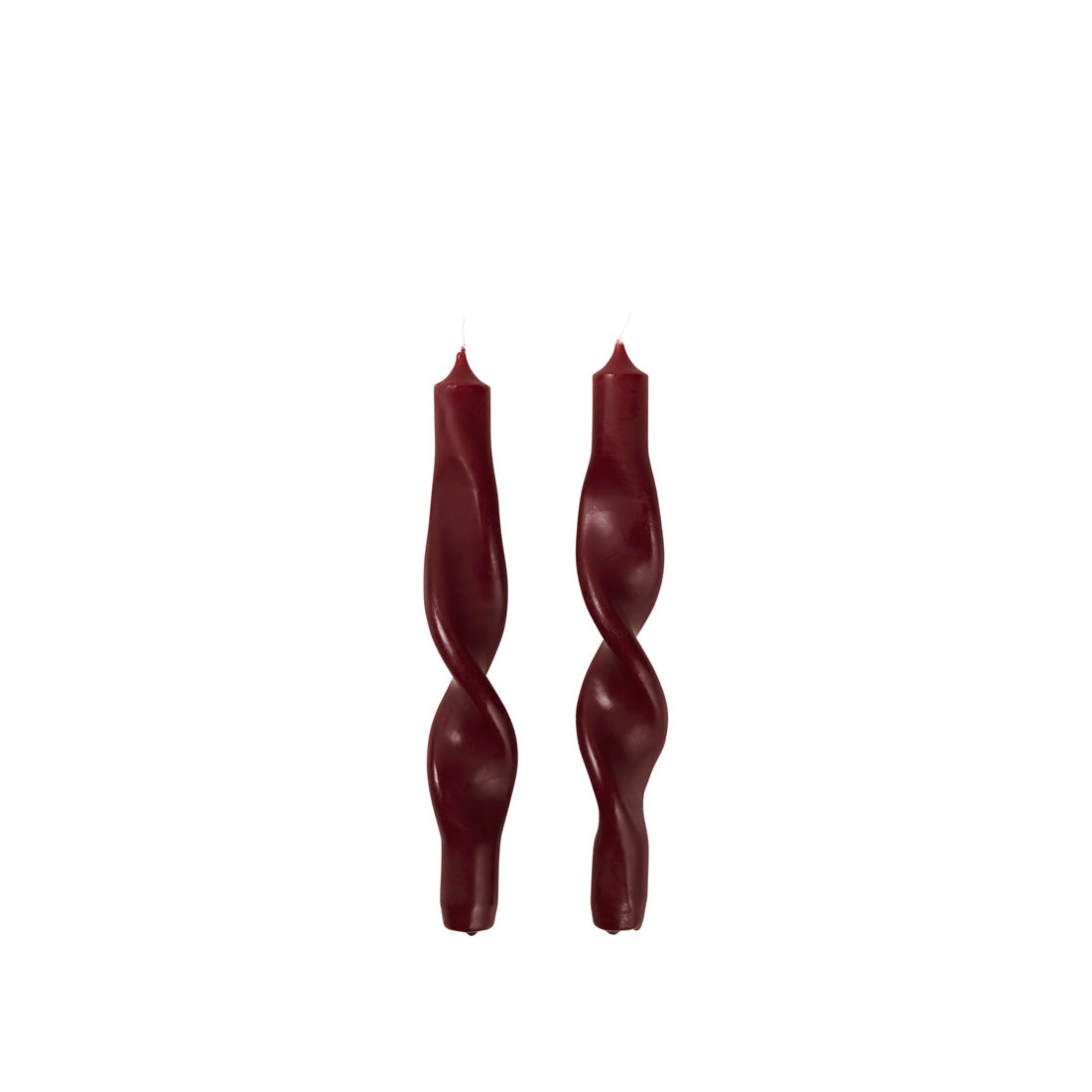 Two Broste Copenhagen matt Twist Taper Candles in burgundy on a white background