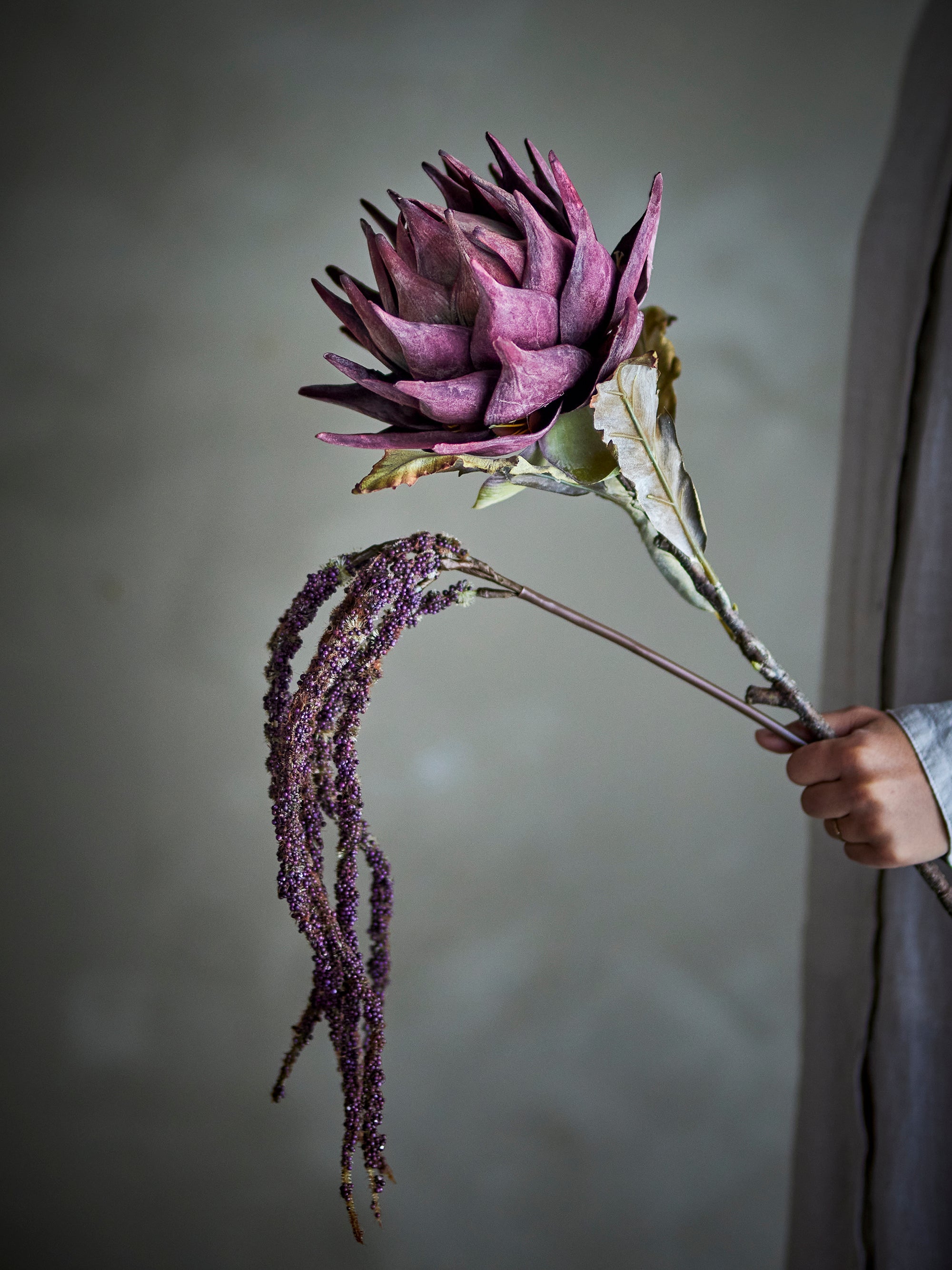 Faux foxtail flower styled in modern vase arrangement