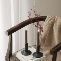 Caramel brown LED dinner candle pair glowing in a soft winter interior