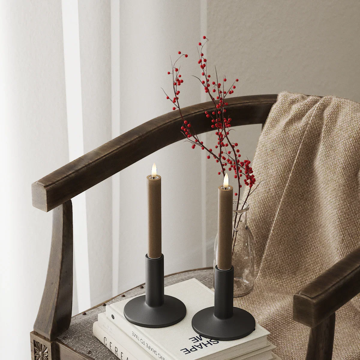 Caramel brown LED dinner candle pair glowing in a soft winter interior