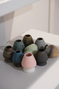 collection of ceramic chasen stands including pastel pink matcha whisk holder
