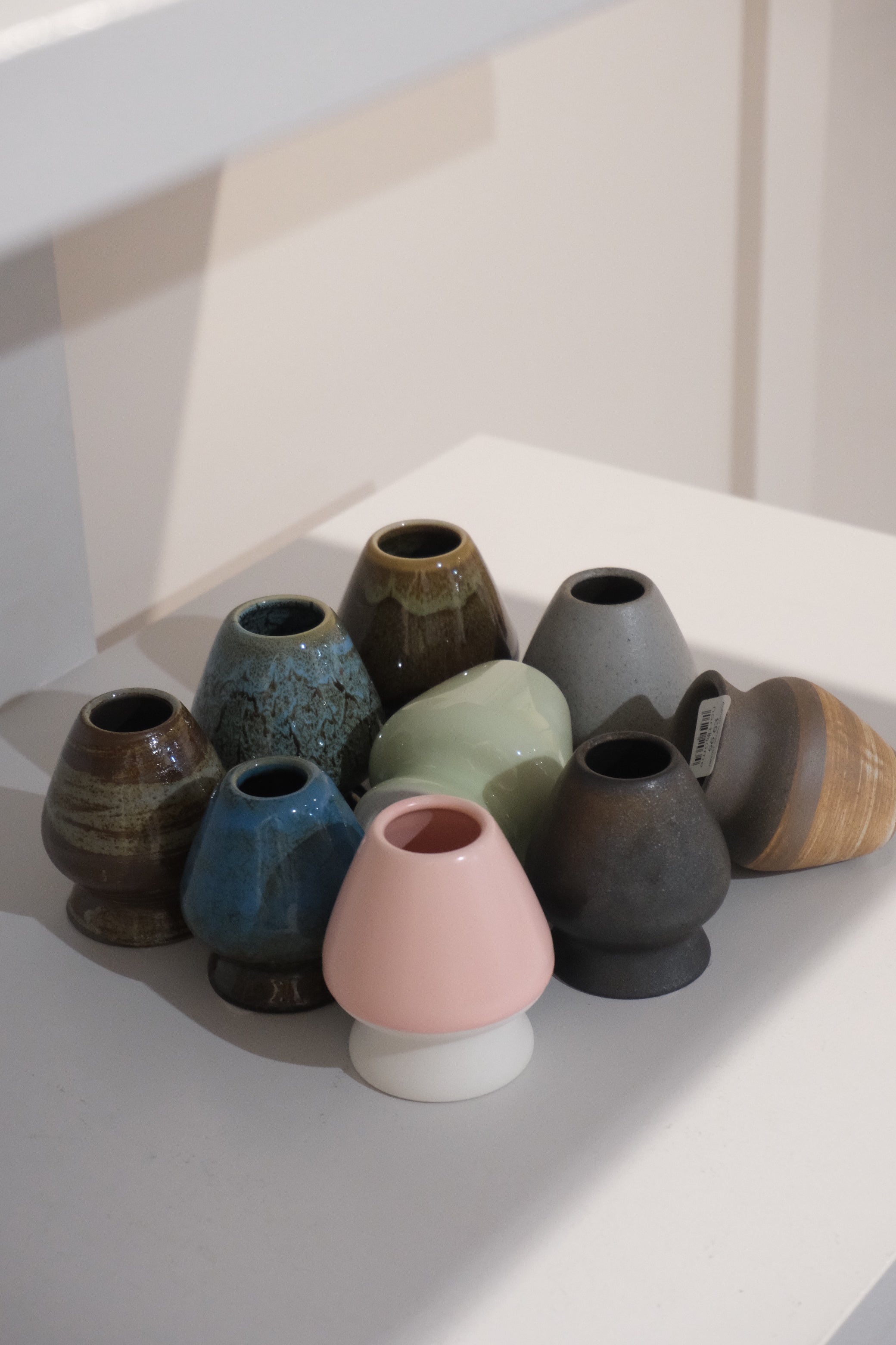 collection of ceramic chasen stands including pastel pink matcha whisk holder
