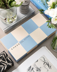 Blue and beige chess set styled with coffee table decor