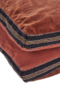 close-up of striped cotton band and velvet texture on burnt red mattress