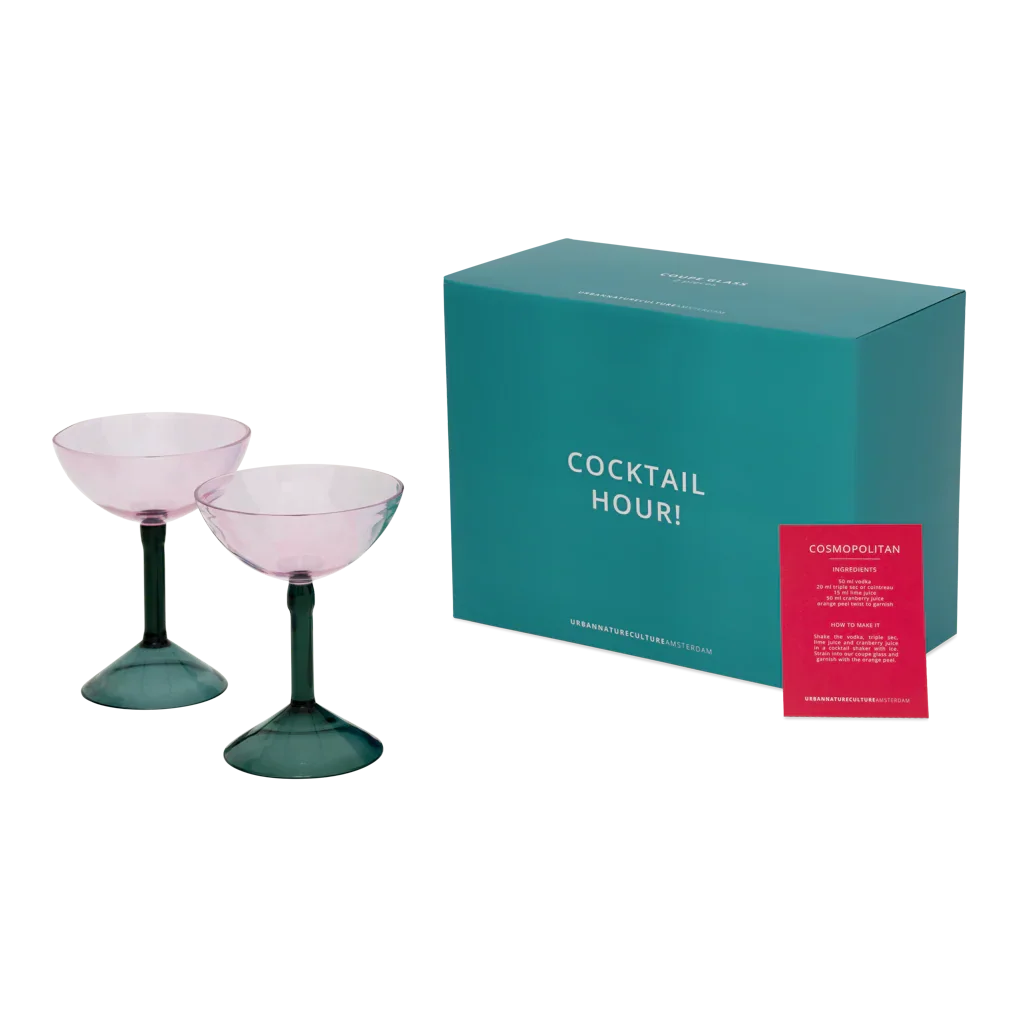 Two rose pink coupe glasses with the teal Cocktail Hour gift box and recipe card
