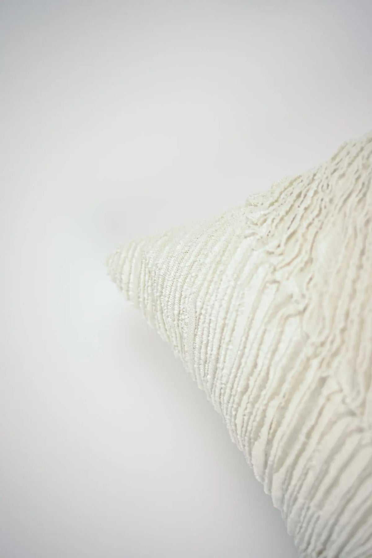 Corner detail of the Elba cream cushion by Olsson & Jensen showing the layered raw-edged cotton strips