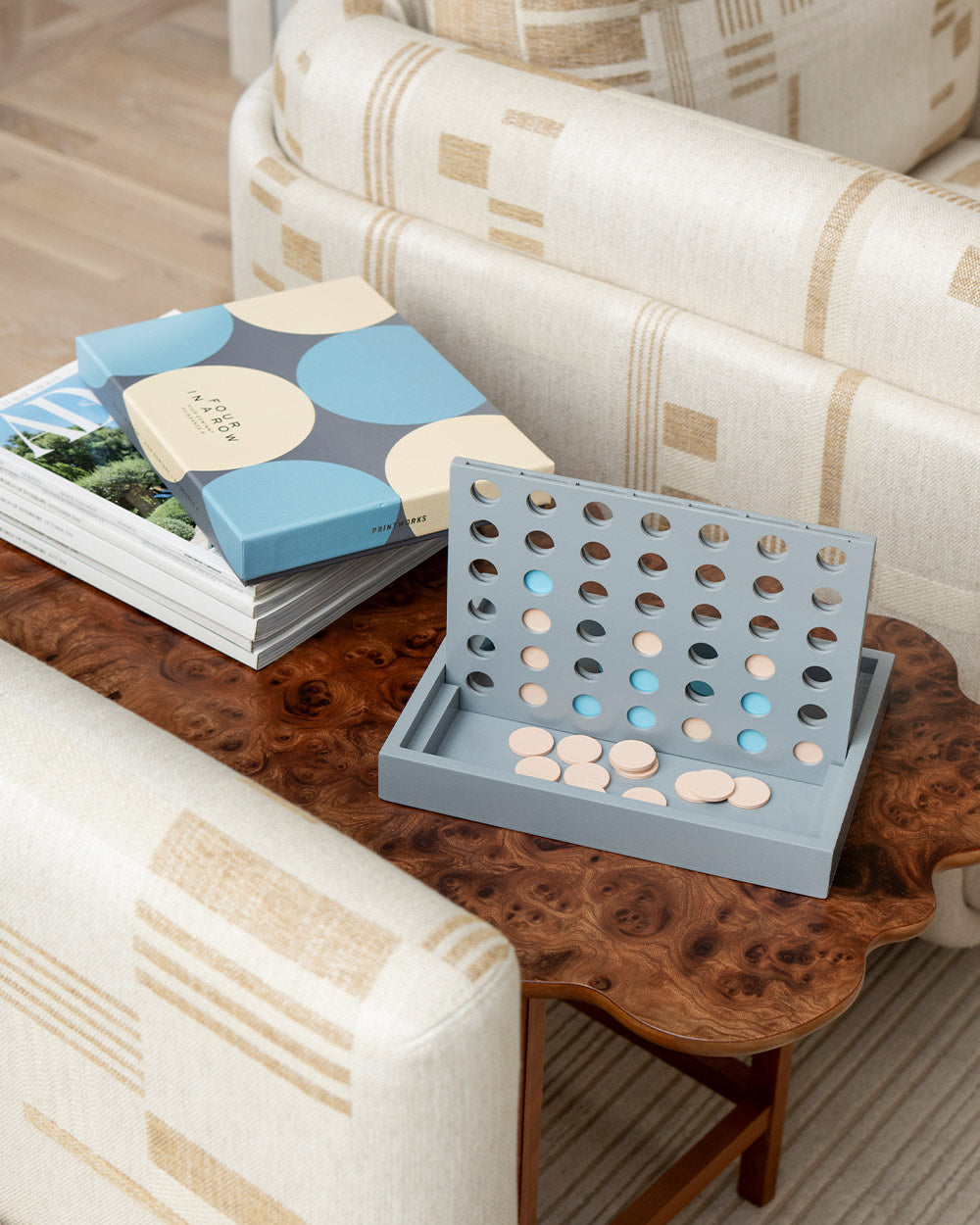 Four in a Row game styled on wooden table with box beside it
