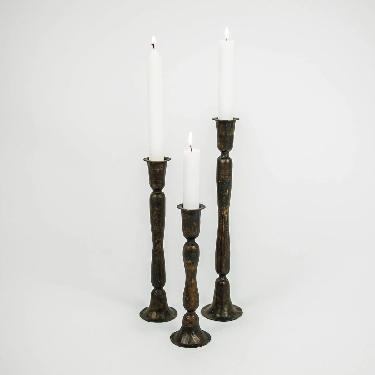 Set of three Gill handmade dark iron taper candlesticks by Olsson & Jensen with white candles