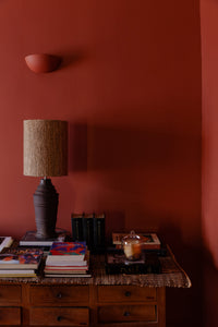 Glass candle dome by Olsson & Jensen on a sideboard beside a table lamp
