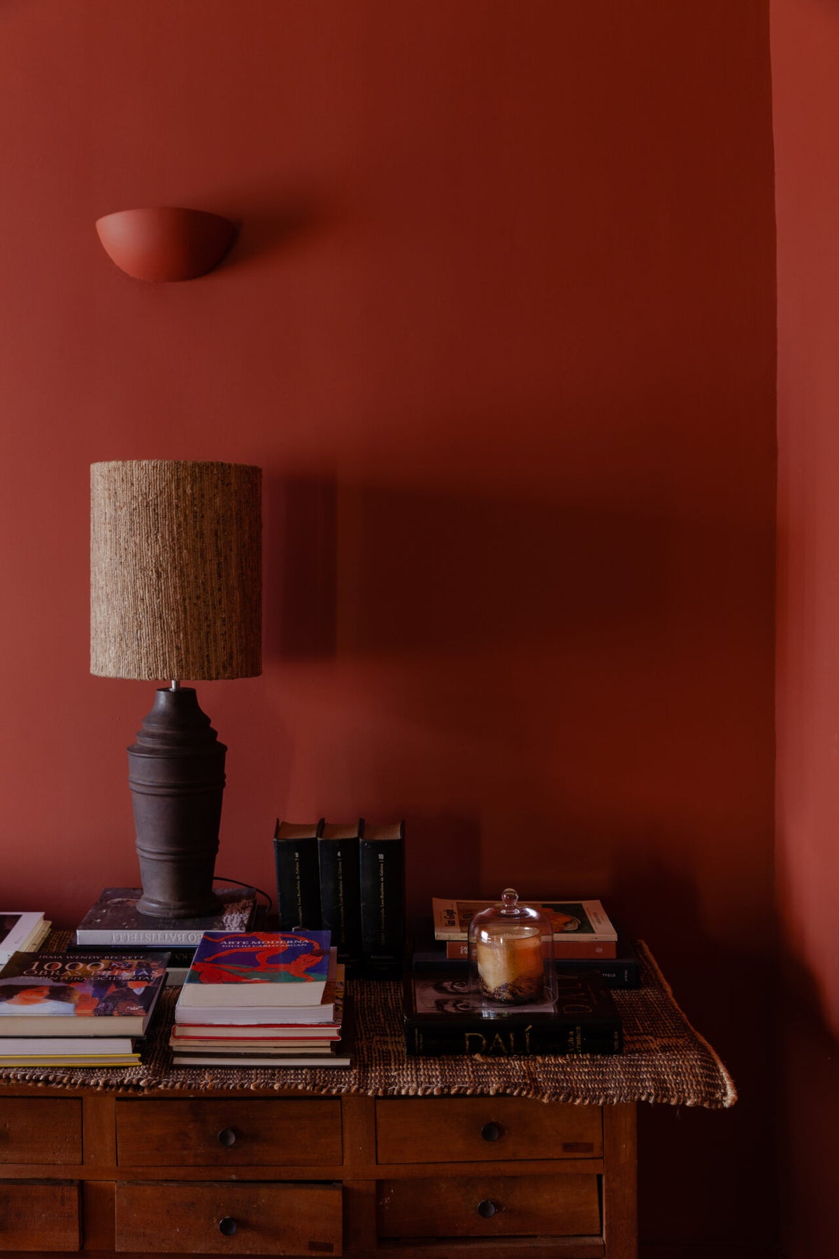 Glass candle dome by Olsson & Jensen on a sideboard beside a table lamp