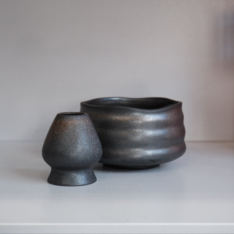 graphite chasen naoshi matcha whisk stand with metallic speckles beside matching bowl
