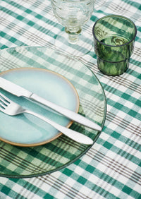 green drinking glass on outdoor table beside salad bowl

