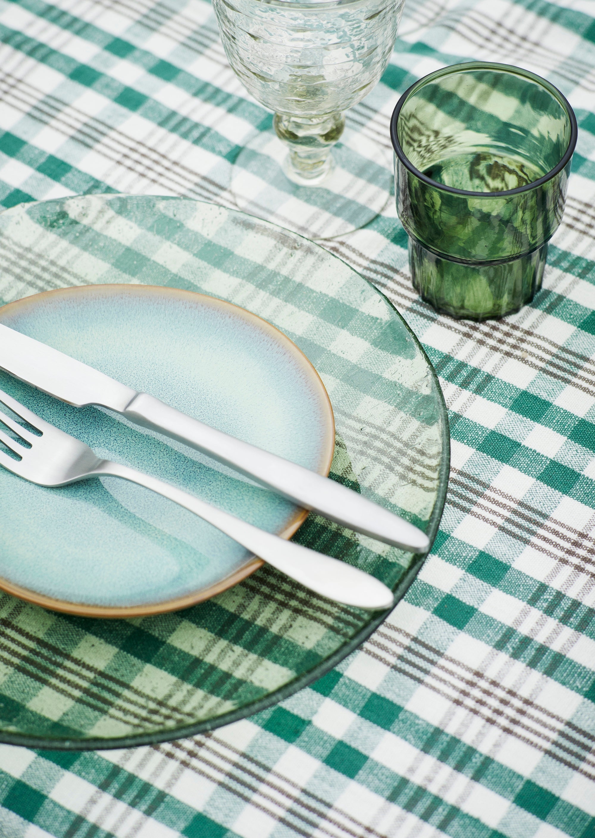 green drinking glass on outdoor table beside salad bowl
