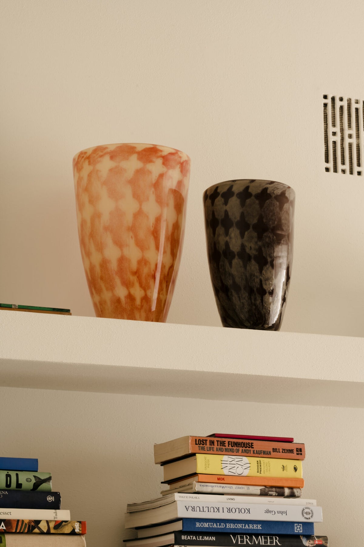 Harley orange and brown vases by Olsson & Jensen on a white shelf above books