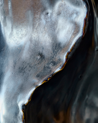 Extreme close-up of the rippled wave detail and warm metallic edges on the handmade House Doctor HDWaves vase, showing the sculptural antique finish