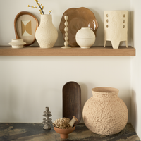 Urban Nature Culture ceramics styled on a wooden shelf above a marble console