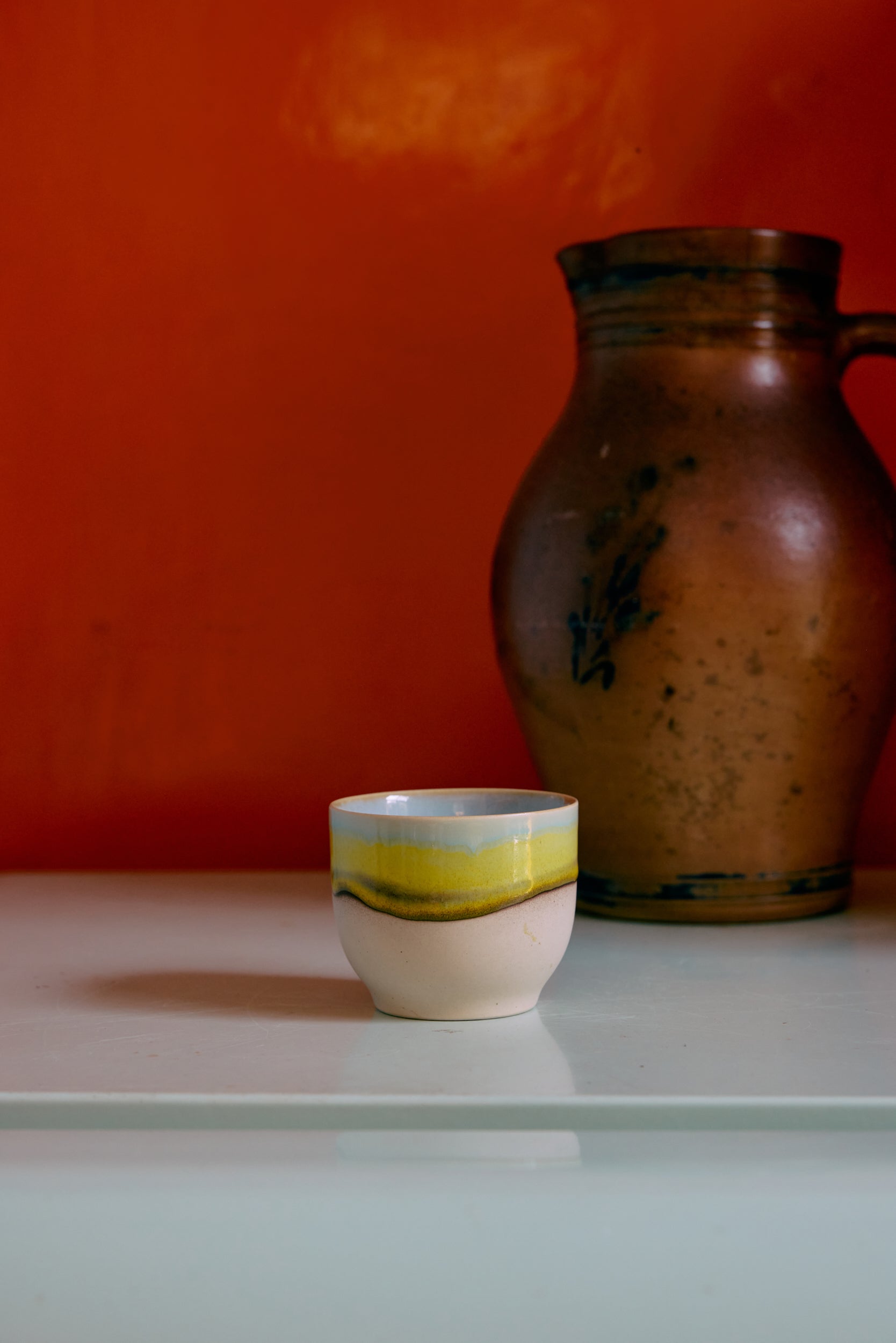 70s ceramics café cup in glint glaze styled on a countertop with warm retro tones
