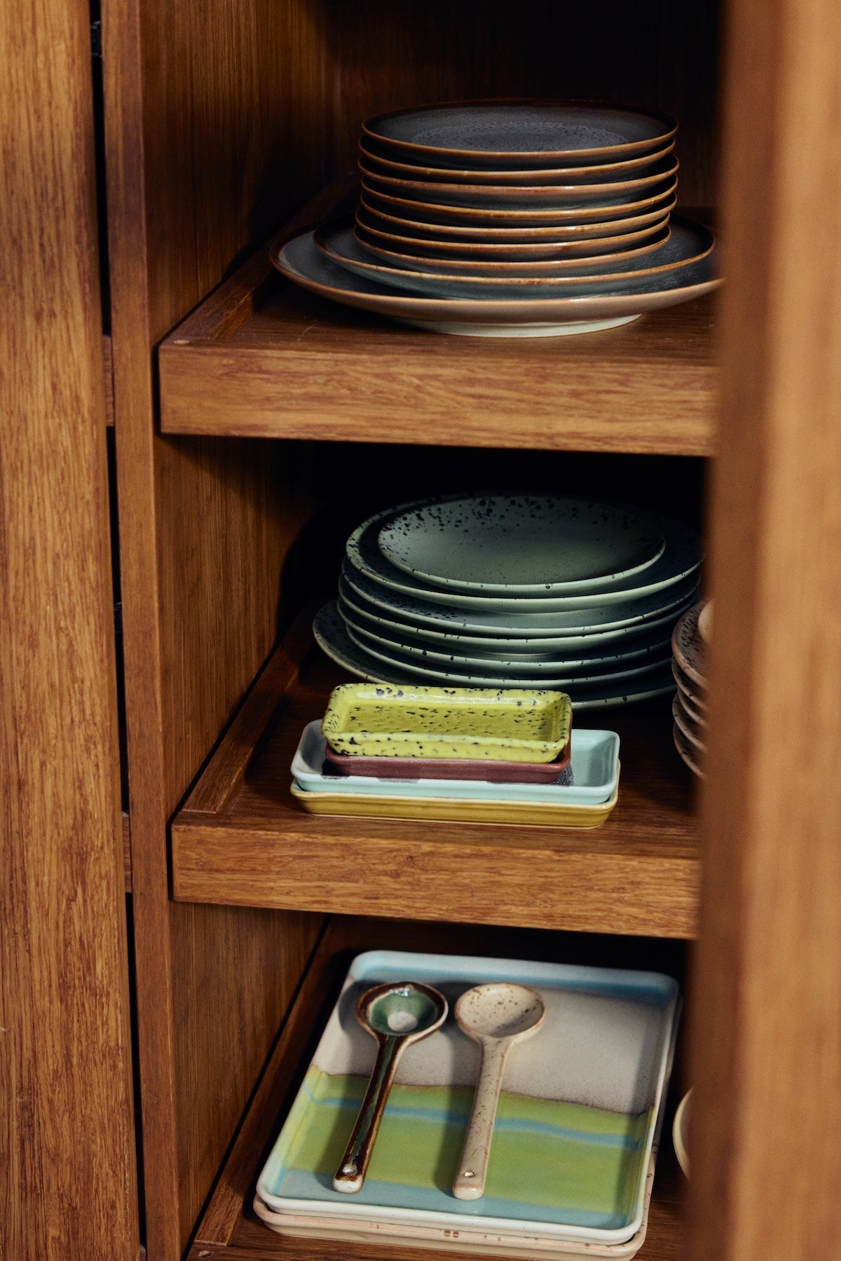 HKLIVING 70s ceramics Hills serving spoons styled in a wooden cabinet with colourful trays