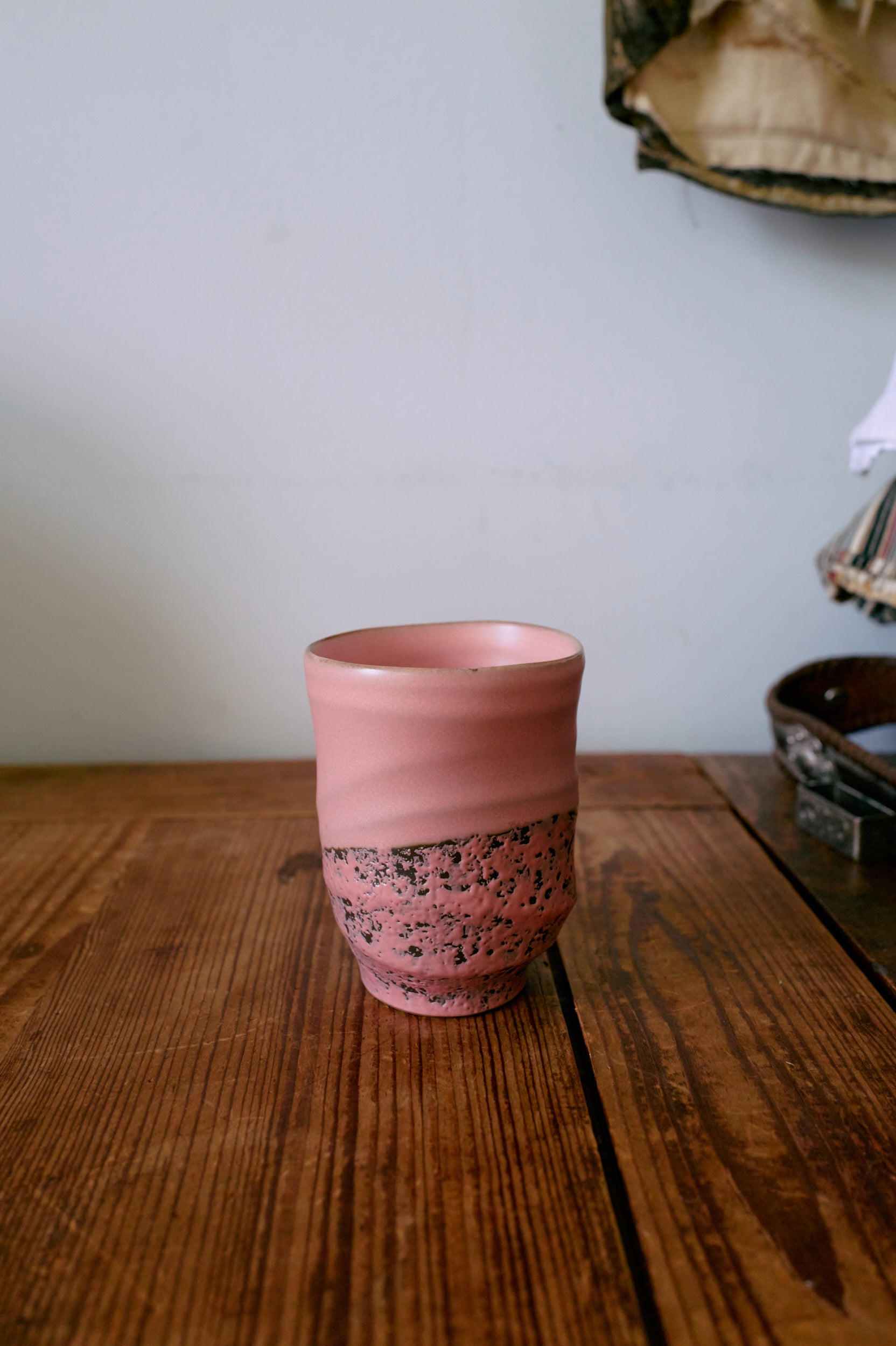 Close view of pink smooth mug with textured base from the set.